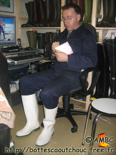 Roger at his desk, wearing white PVC boots, 2006.