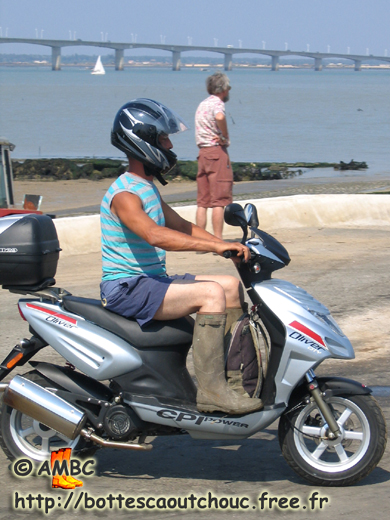 Young rubberbooted biker in shorts, Bourcefranc, France, 14 July 2006. Gummistiefel, rubber boots, bottes caoutchouc.