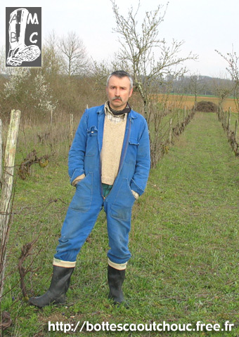 In blue overalls in the vineyard.
