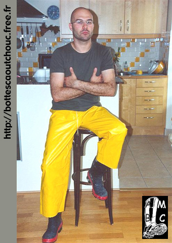 Wearing PVC trousers in his kitchen.