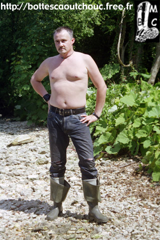 Wearing wet PVC waders.