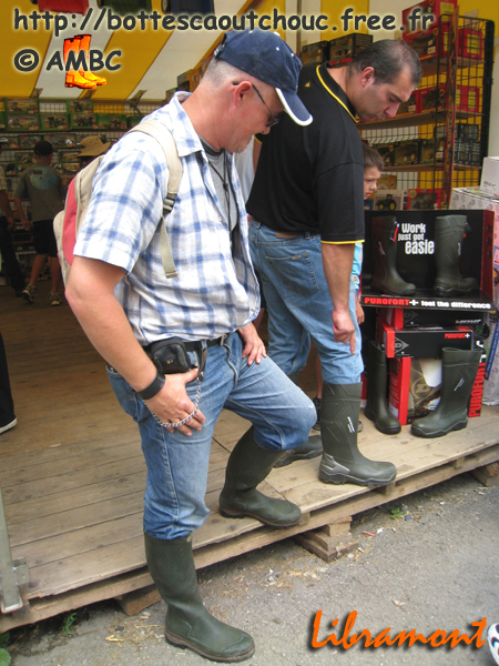 A salesman from Dunlop showing his wellies for sale to Pascal. Gummistiefel, botas de goma, bottes en caoutchouc, rubber laarzen, Libramont, Belgium 2008.
