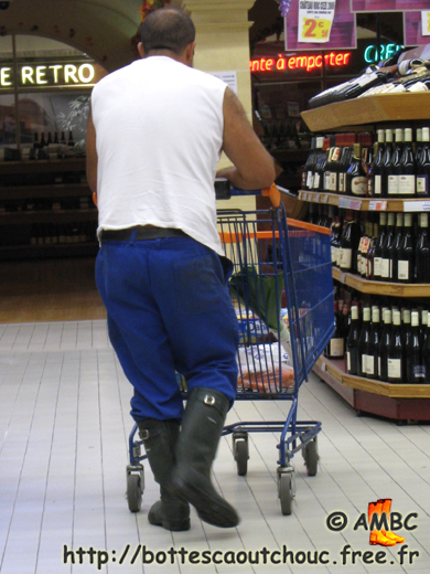 Guy wearing blue working gear and gumboots, at Leclerc supermarket, 2010. Gummistiefel, wellies, botas de goma, stivali di gomma, rubber laarzen, bottes caoutchouc.