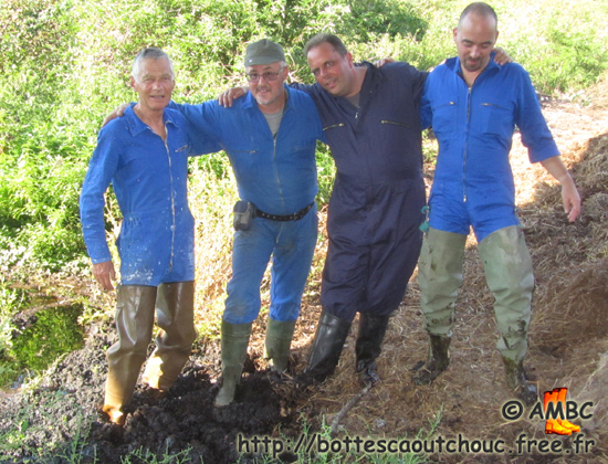 Rubberbooted fans in coveralls in the manure; France,  Sept. 2011.